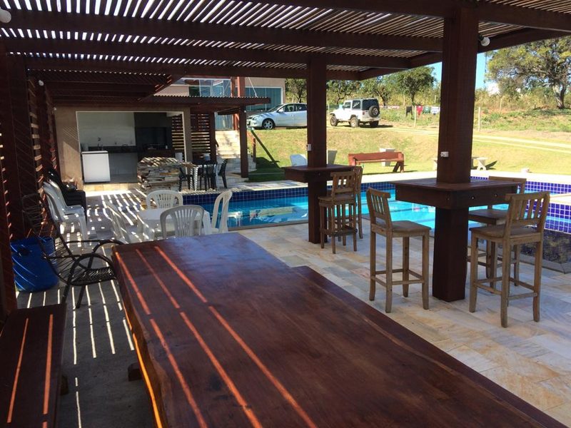 Área coberta ao lado da piscina, com mesas