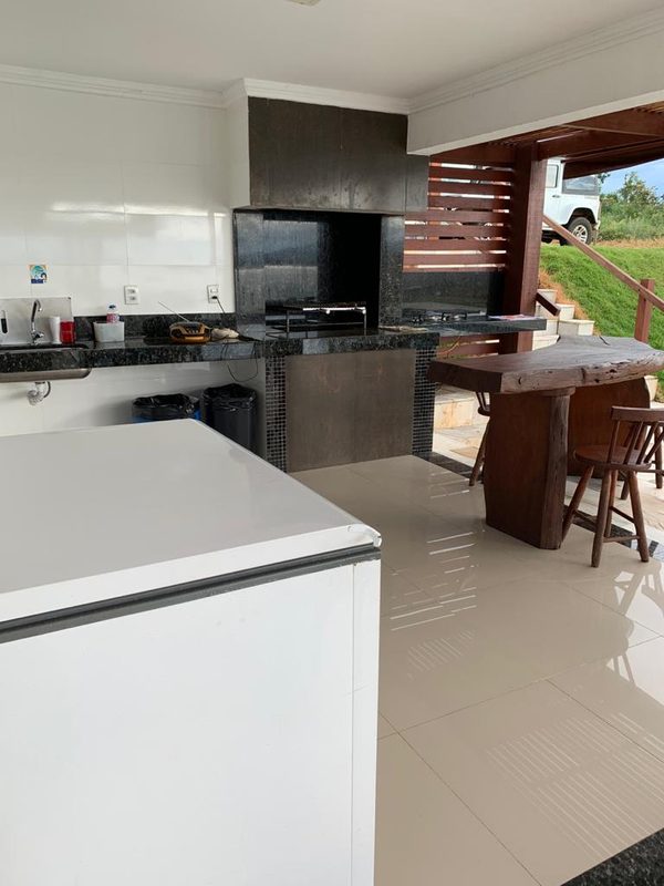 Área de churrasco com bancada de granito, ao lado da piscina