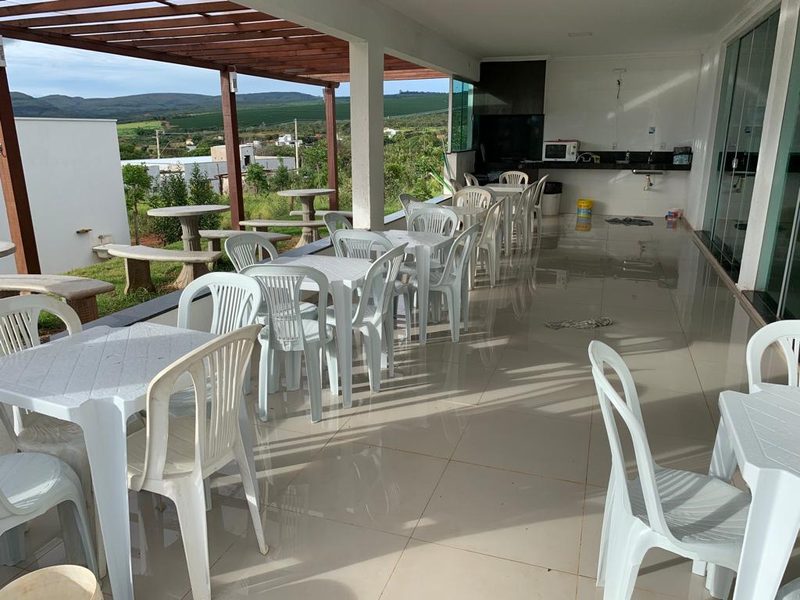 Varanda coberta da casa com mesas e cadeiras